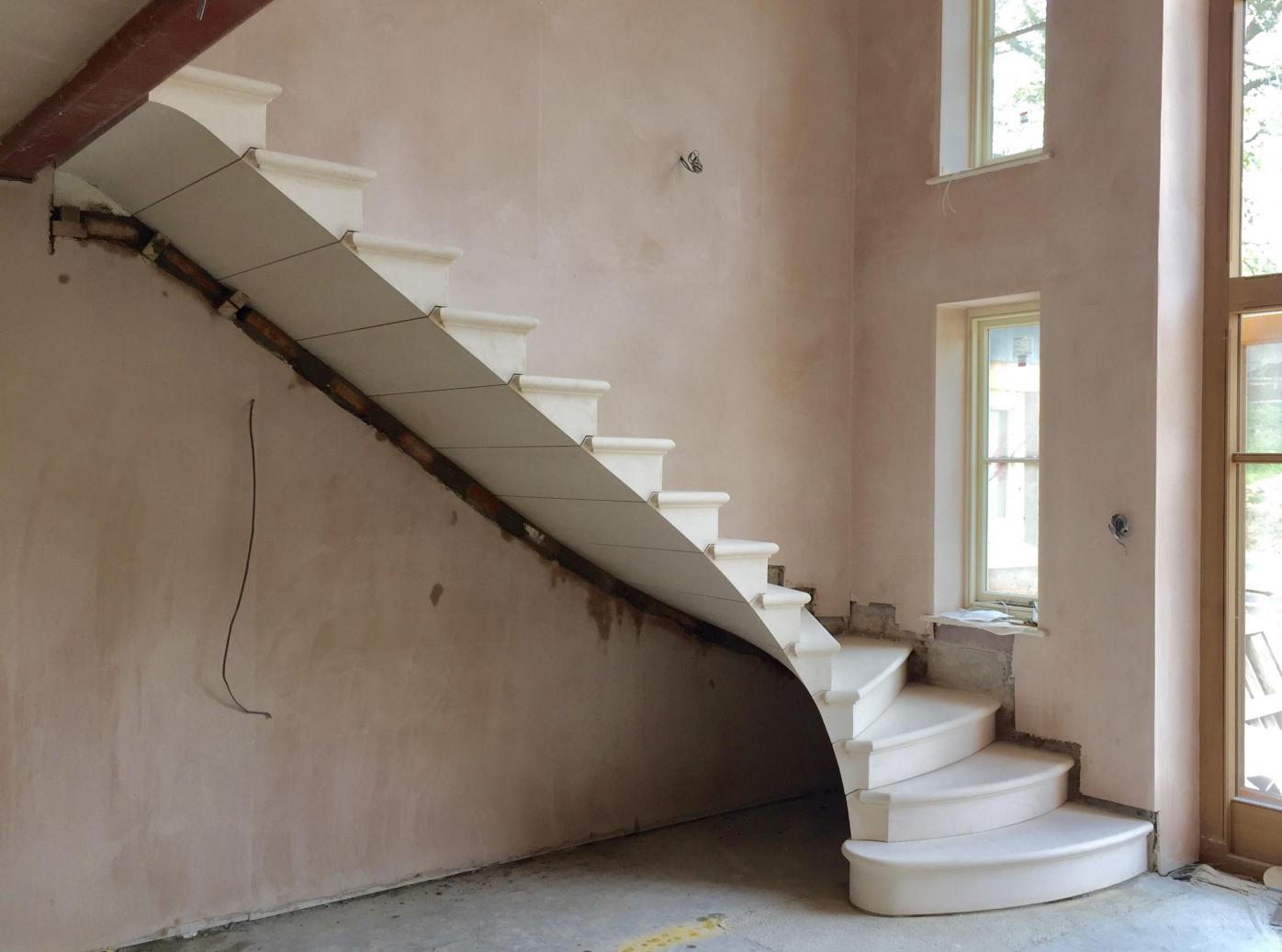 cantilevered stone staircase with seamless soffit 